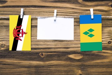 Hanging flags of Brunei and Saint Vincent And The Grenadines attached to rope with clothes pins...