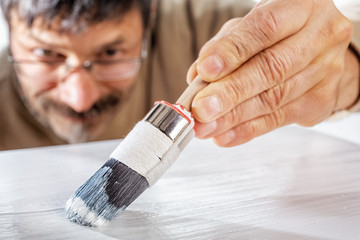 Applying white primer paint on wood