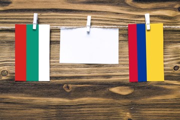 Hanging flags of Bulgaria and Colombia attached to rope with clothes pins with copy space on white...