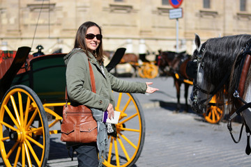Fototapeta na wymiar the girl near the horses and the carriages in the center of Seville Spain