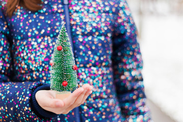 Small Christmas tree in the hands of a child. Festive Christmas background, Christmas and New year spirit