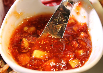 Savory fig Jam, in a white serving dish, with a spreading knife.