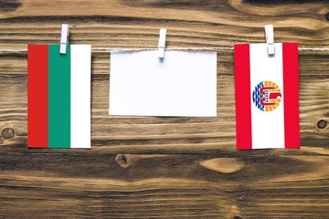 Hanging flags of Bulgaria and French Polynesia attached to rope with clothes pins with copy space...