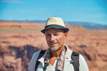 Fototapeta premium Happy man with straw hat enjoying Horseshoe Bend and Colorado River in the summer season