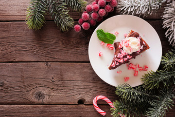 Christmas candy cane chocolate cheesecake. Top view corner border over a dark wood background with copy space.