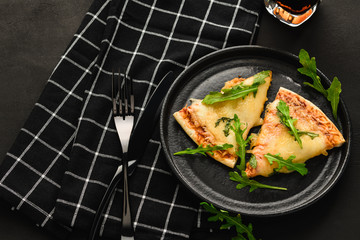 Pizza on a black background, on a plate with a drink