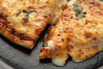 Pizza on a black background, on a plate with a drink
