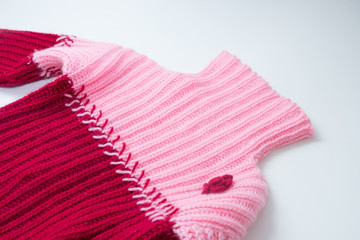 women's knitted woolen pink with a burgundy sweater on a white table