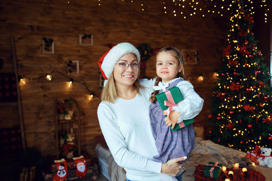 Mom with her daughter with gifts at Christmas.