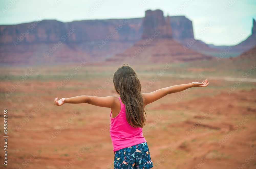 Sticker Happy young girl with oper arms embracing Monument Valley