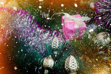 Fototapeta na wymiar Beautiful christmas background with christmas tree and christmas balls. In the background there are rays of the sun and snowflakes. Modern design. Background, texture