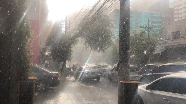 Pouring rain during bright sunny day in city Sunshower sidewalk