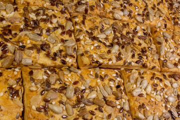 Cookies sprinkled with sunflower, sesame and flax grains, stacked in rows.