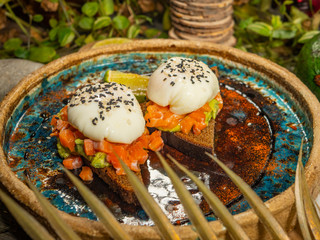 Tasty sandwiches with red fish and guacamole sauce on toasted black bread