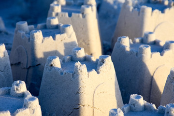 Sand castles on a beach at sunset bring back childhood memories.