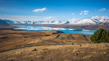 The turquoise waters of Lake Tekapo reflect surrounding snow-capped mountains, Lake Tekapo, New...