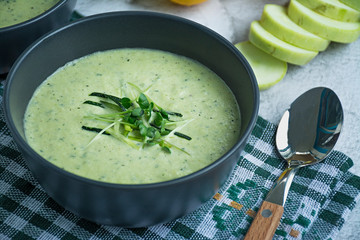 Cream soup made from mashed potatoes with zucchini and basil and crackers on a light background. Space for text.