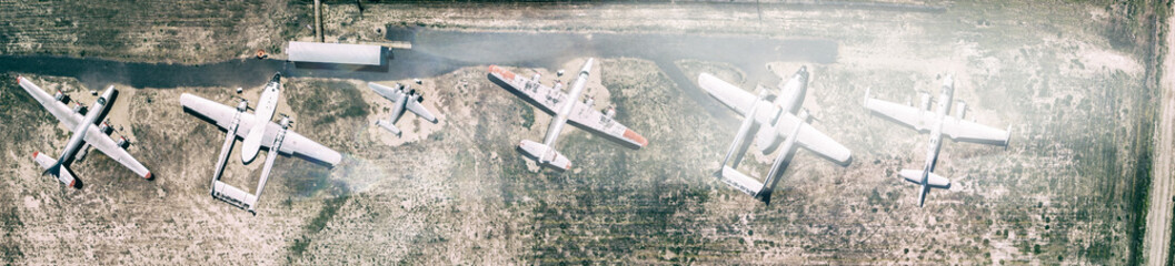 Naklejka na ściany i meble Aerial top downward view of symmetric parked light old aircrafts at a small countryside airfield. Travel and holiday concept