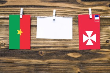 Hanging flags of Burkina Faso and Wallis And Futuna attached to rope with clothes pins with copy...