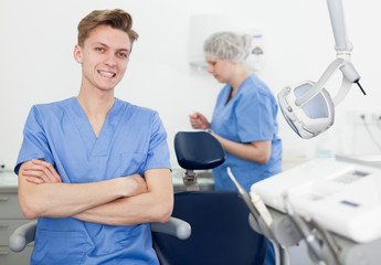 Male dentist in dental office with hands crossed