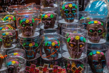 Fototapeta premium Chocolate and sequin skulls, typical sweets during the time of the day of the dead in Mexico, toy offerings made with crumbs and icing sugar