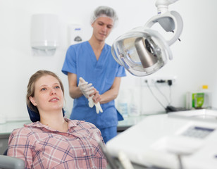 Young female patient sitting in dental chair waiting for medical examination in the dental clinic