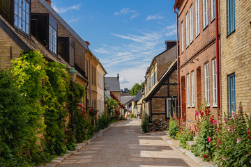 A cosy cobblestone street with half-timbered houses in the old parts of the medieval university city of Lund, Sweden.
