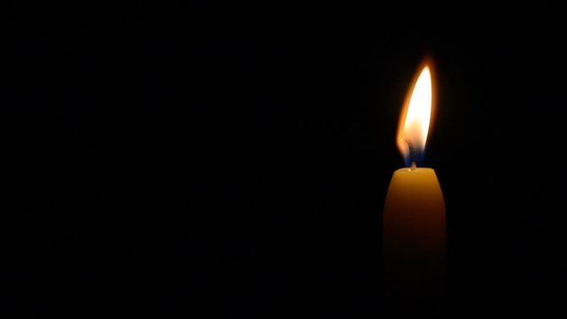 Simple burning candle on a black background, left balck copyspace hd stock footage