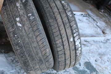 Obraz premium photo of old car wheels. they are round, standing against the wooden wall of the garage.summer tires removed from the car.on the rubber protector.