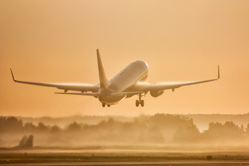 Passenger airplane take off in morning fog