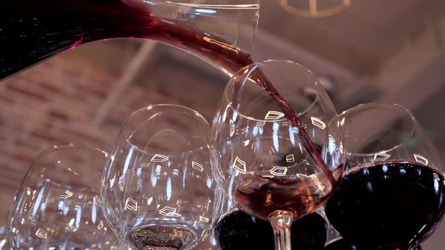 bartender pours wine into glasses