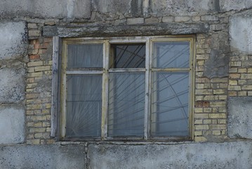 Fototapeta na wymiar old one window with grille on the brick wall