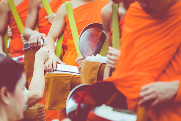 Buddhist alms giving ceremony in the morning. The tradition of giving alms to monks in Luang...