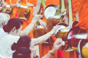 Buddhist alms giving ceremony in the morning. The tradition of giving alms to monks in Luang Prabang. Laos. - obrazy, fototapety, plakaty