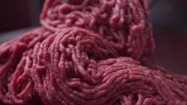 Processing lard or meat in minced meat on a huge meat grinder at a meat factory closeup.