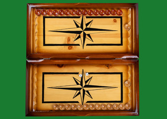 Dice and checkers on a wooden backgammon board over a green background.