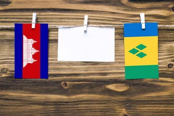 Hanging flags of Cambodia and Saint Vincent And The Grenadines attached to rope with clothes pins...