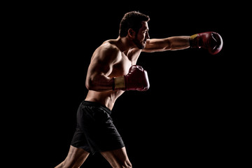 Fototapeta na wymiar Strong muscular man with boxing gloves throwing a punch