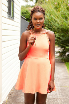 Portrait of young woman holding flower outdoors
