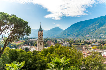 Ansicht alte Stadt Meran in Südtirol mit Bergen, blauem Himmel und Pfarrkirche St. Nikolaus 