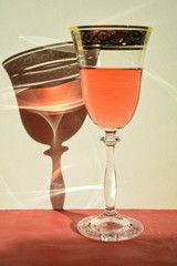 rose wine in a glass on a cantaloupe table and a shadow from the glass