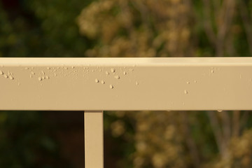 Metal railings with rain drops in sunlight