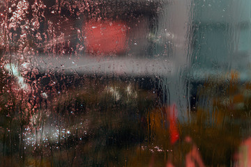 Wet window glass with colorful blurs and sparkles