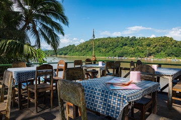 Traditional Long Boat on the Mekong River and mountains view in Luang Prabang, Laos.