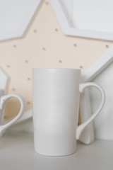 Fototapeta na wymiar White tea mug on the shelf