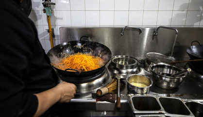 Traditional preparing food and professional Chinese cooks at kitchen.