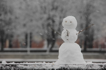 The snowman raised his hands. Symbol of winter, new year. Modeling of snow