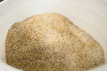 Ground barley in container, grinding barley.