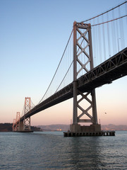 Fototapeta na wymiar San Francisco side of Bay Bridge at dusk with bird in the air
