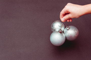 Christmas tree toys in child's hand. Free copy space.